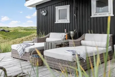 two wicker chairs and a table on a patio at LK2173-Lokken-Ruthsvej-9 in Løkken