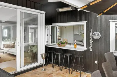 a kitchen with a counter and stools in a room at LK2173-Lokken-Ruthsvej-9 in Løkken