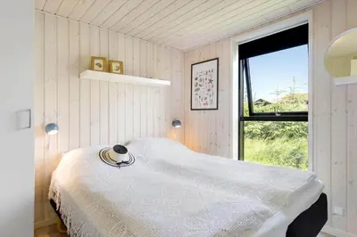 a bedroom with a white bed and a window at BL1511-Saltum-Tolhoj-21 in Saltum