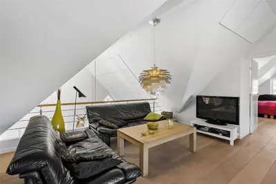 a living room with a black leather couch and a tv at BL672-Pandrup-Strandfogdensvej-56 in Pandrup