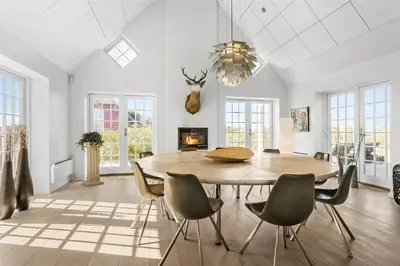a dining room with a table and chairs and a fireplace at BL672-Pandrup-Strandfogdensvej-56 in Pandrup