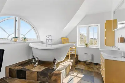 a bathroom with a large tub and two sinks at BL672-Pandrup-Strandfogdensvej-56 in Pandrup