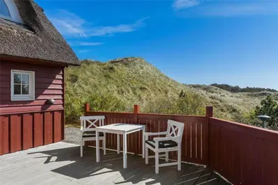 a patio with two chairs and a table on a deck at BL672-Pandrup-Strandfogdensvej-56 in Pandrup