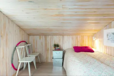 a bedroom with a bed and a chair in a room at BL1587-Blokhus-Karnoevej-1 in Blokhus