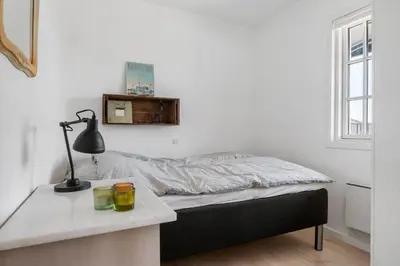 a bedroom with a bed and a desk with a lamp at BL1637-Blokhus-Norresundbyvej-2 in Blokhus