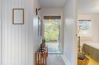 a room with a bed and a table and a window at BL946-Blokhus-Graevlingevej-8 in Blokhus