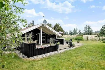 a cabin in the middle of a grass field at BL1438-Blokhus-Bloksbjerg-82 in Blokhus