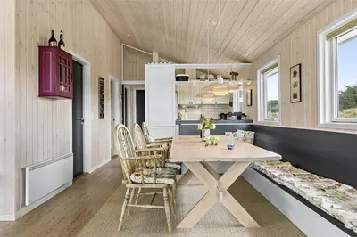 a kitchen and dining room with a table and chairs at BL819-Blokhus-Pirupshvarrekrogen-2 in Blokhus