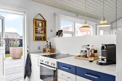 a kitchen with a stove top oven next to a window at BL1425-Blokhus-N-S-Larsensvej-6 in Blokhus
