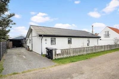 a white house with a fence in front of it at BL1425-Blokhus-N-S-Larsensvej-6 in Blokhus