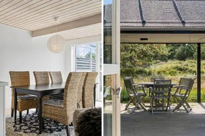 a patio with a black dining table and chairs at BL1619-Blokhus-Klitheden-Nord-42 in Blokhus