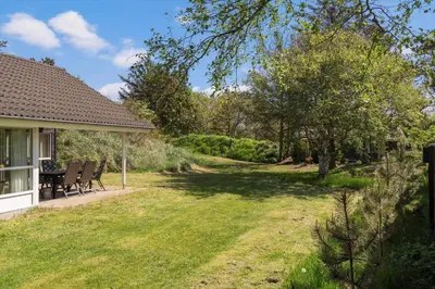 a yard with chairs and a table in a house at BL1382-Blokhus-Gyvelvej-20-A in Blokhus