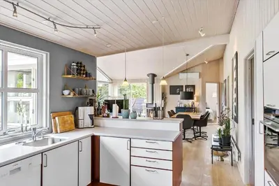 a kitchen with white cabinets and a dining room at BL1577-Blokhus-Lars-Liensvej-27 in Blokhus