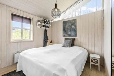 a bedroom with a large white bed and a window at BL1577-Blokhus-Lars-Liensvej-27 in Blokhus