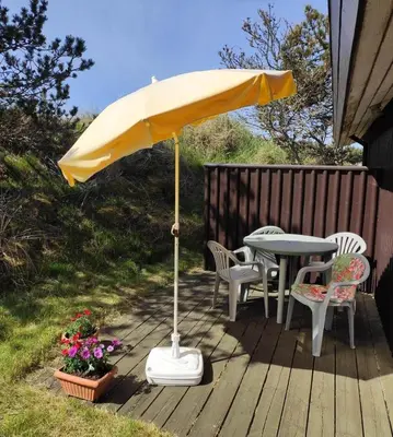 a yellow umbrella on a deck with a table and chairs at BL1225-Pandrup-Flaskehalsen-1 in Pandrup