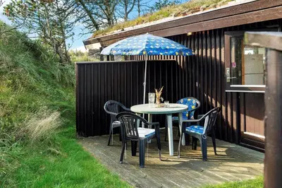 a table and chairs with an umbrella on a patio at BL1225-Pandrup-Flaskehalsen-1 in Pandrup