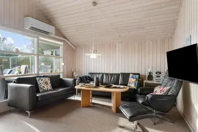 a living room with black leather furniture and a table at BL1255-Pandrup-Rodhusparken-63 in Pandrup