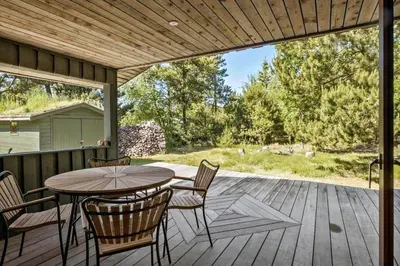 a patio with a table and chairs on a deck at BL1735-Pandrup-Rodhus-Skolevej-56 in Pandrup