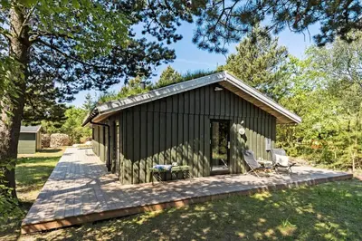 a small black shed with a porch in a yard at BL1735-Pandrup-Rodhus-Skolevej-56 in Pandrup