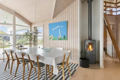 a dining room with a table and a fireplace at BL189-Saltum-Bondagervej-71 in Saltum