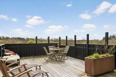 a patio with a table and chairs on a deck at BL189-Saltum-Bondagervej-71 in Saltum