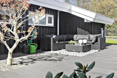 a patio with two couches and a tree at BL1566-Saltum-Lille-Fiskerbanke-3 in Saltum