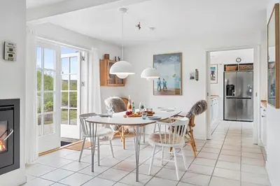 a kitchen and dining room with a table and chairs at BL1401-Blokhus-Ferren-Syd-78 in Blokhus