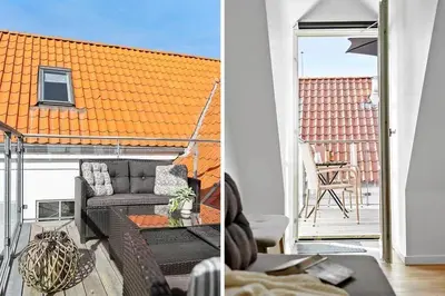 a living room with a couch and a table on a balcony at BL1582-Blokhus-Strandvejen-14-Lejl-11 in Blokhus