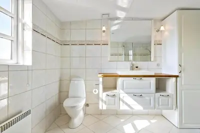 a white bathroom with a toilet and a sink at BL1548-Blokhus-Paa-Bakken-10 in Blokhus