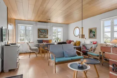 a living room with a couch and a table at BL1548-Blokhus-Paa-Bakken-10 in Blokhus