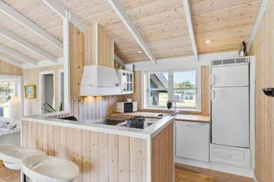 a kitchen with wooden walls and a white refrigerator at BL959-Saltum-Nordvestvej-6 in Saltum
