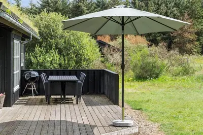 a patio with a table and an umbrella at BL959-Saltum-Nordvestvej-6 in Saltum