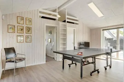 a ping pong table in a room with a chair at BL1470-Saltum-Faaborgvej-6 in Saltum