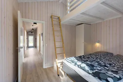 a bedroom with a bunk bed and a ladder at BL1783-Blokhus-Lyngbakkevej-9 in Blokhus