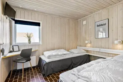 a bedroom with two beds and a desk and a chair at BL1775-Pandrup-Rodhus-Klitvej-335 in Pandrup