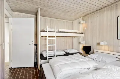 a bedroom with two bunk beds and a ladder at BL1775-Pandrup-Rodhus-Klitvej-335 in Pandrup
