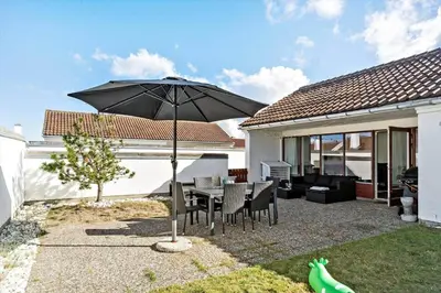 a patio with a table and an umbrella at BL1775-Pandrup-Rodhus-Klitvej-335 in Pandrup