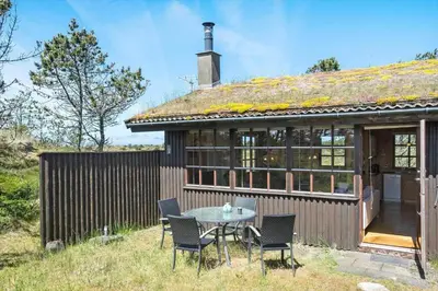 a small house with a table and chairs outside at BL1570-Pandrup-Flaskehalsen-13-A in Pandrup