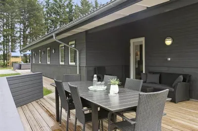 a black table and chairs on a wooden deck at BL1358-Saltum-Solmarken-5 in Saltum
