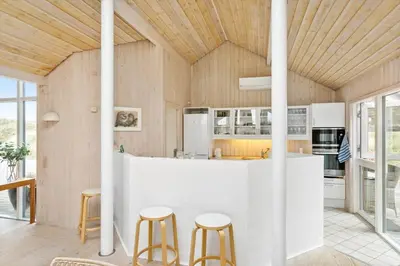 a kitchen with a white counter and stools at BL247-Saltum-Haresvinget-9 in Saltum