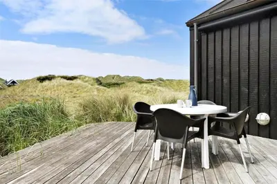 a table and chairs sitting on a wooden deck at BL247-Saltum-Haresvinget-9 in Saltum