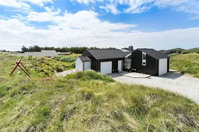 a black and white house in the middle of a field at BL247-Saltum-Haresvinget-9 in Saltum