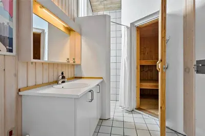 a white bathroom with a sink and a mirror at BL247-Saltum-Haresvinget-9 in Saltum
