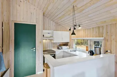 a kitchen with a white counter and a green door at BL224-Pandrup-Rodhusparken-91 in Pandrup