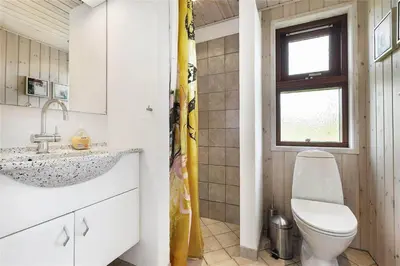 a bathroom with a toilet and a sink and a window at BL852-Saltum-Revlingevej-14 in Saltum