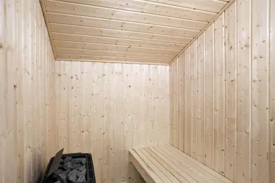 a wooden sauna with a bench in the corner at BL377-Blokhus-Maxvej-9 in Blokhus