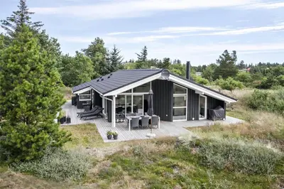 a black house in the middle of a field at BL377-Blokhus-Maxvej-9 in Blokhus