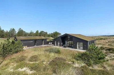 a black house in the middle of a field at BL1231-Pandrup-Lunen-54 in Pandrup