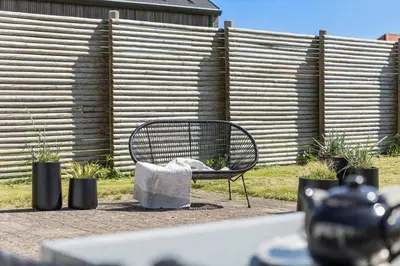 a bench sitting in front of a fence at BL509-Blokhus-Jens-Baerentsvej-7 in Blokhus