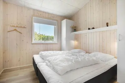 a large bed in a room with a window at BL1748-Blokhus-Grossvej-5 in Blokhus